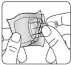 Hand holding an applicator with a needle inserted into a transparent adhesive disk for skin administration