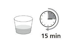 Glass with clear liquid next to a clock showing 12 with an arrow indicating 15 minutes
