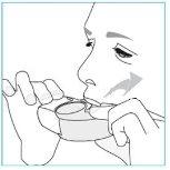 Person applying a mouthpiece inhaler with hands holding the device near the lips