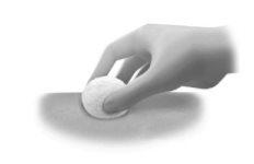 Hand holding a white cotton ball pressing on the skin with a slight angle