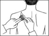 Hand applying a circular medicinal patch to the neck of a person with the other hand holding the applicator