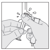 Mano che tiene una siringa preriempita con ago protetto e un batuffolo di cotone imbevuto di alcol vicino al sito di iniezione