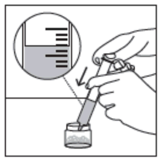 Mano che preleva farmaco liquido da flacone con siringa graduata trasparente e ago inserito