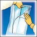 Mano con guanto giallo che apre una busta sigillata trasparente contenente un dispositivo medico sottile e scuro