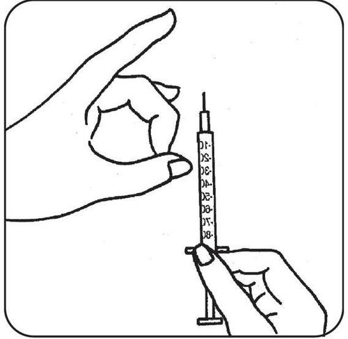 Mano che tiene una siringa con ago rivolto verso l