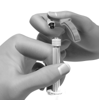 Mano che inserisce un ago in un adattatore grigio collegato a una fiala trasparente con stantuffo bianco