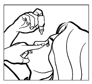 Mano che tiene un flacone contagocce mentre somministra gocce nell