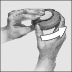 Mani che tengono un dispositivo medico rotondo e scuro con una freccia bianca che indica il movimento di applicazione