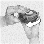 Mano che tiene un dispositivo autoiniettante nero con una freccia bianca che indica la rotazione del cappuccio protettivo