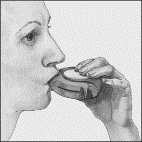 Mano che tiene un inalatore orale bianco e grigio posizionato nella bocca aperta di un paziente