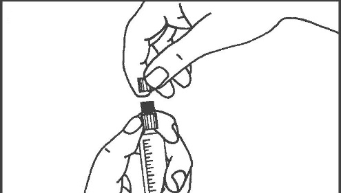 Mano che tiene una fiala di vetro con un tappo nero e una siringa pronta per l