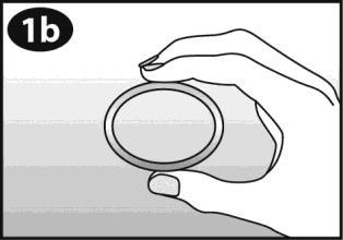 Mano che afferra un anello trasparente sopra una superficie a strisce grigie chiare e scure numero 1b in alto a sinistra