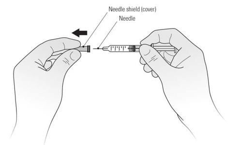 Mani che tengono una siringa preriempita con ago inserito e protezione dell