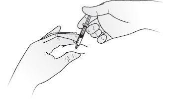 Mano che tiene una siringa pronta per l