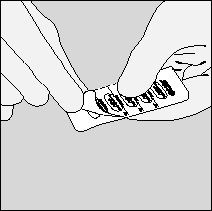 Mani che aprono una confezione blister di compresse farmaceutiche bianche e grigie