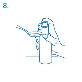 Mano che tiene un flacone e versa una dose di liquido in un cucchiaio da miscela blu