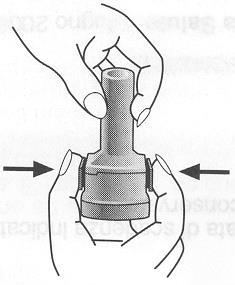 Mano che afferra un dispositivo cilindrico con due anelli neri e frecce laterali che indicano la direzione di pressione