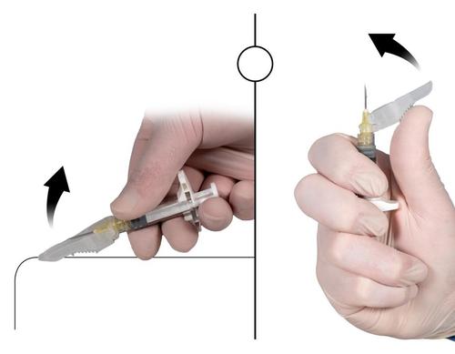 Mano con guanto che tiene una siringa pronta per l