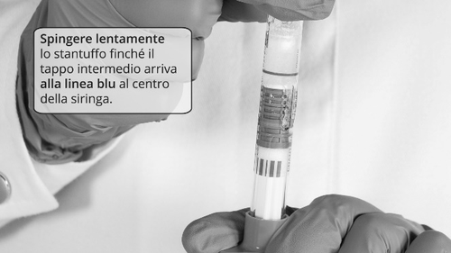 Mano che tiene una siringa preriempita con stantuffo e indicatore blu centrale durante l