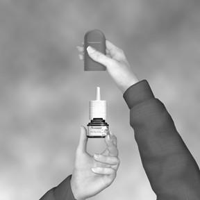 Mano che tiene un flacone spray nasale bianco e nero con un