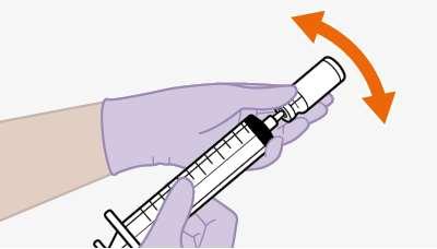 Mano con guanto viola che impugna una siringa trasparente con scala graduata e ago arancione con freccia curva indicante la direzione