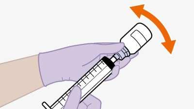 Siringa con ago in mano guantata viola, freccia arancione curva indica rotazione del dispositivo