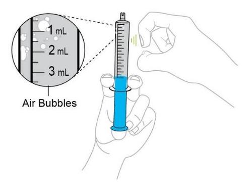 Mano che tiene una siringa piena di liquido blu, con indicazioni di misurazione in ml e dettaglio di bolle d