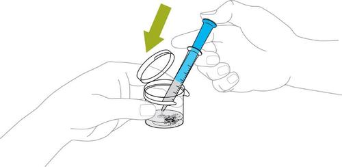 Mano che tiene una siringa blu sopra un flacone di vetro con polvere e un tappo di plastica aperto freccia verde indica la direzione