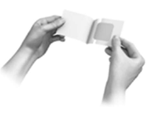 Due mani che tengono e aprono una bustina sigillata contenente un cerotto medicato di colore chiaro