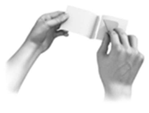 Mani che aprono un foglietto illustrativo piegato a metà mostrando il testo e le istruzioni per l