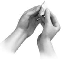 Mani che aprono un involucro metallico sigillato contenente un farmaco probabilmente in polvere o granuli