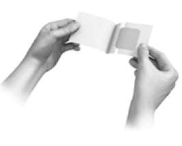 Mani che aprono una bustina sigillata contenente un cerotto medicato adesivo di colore beige