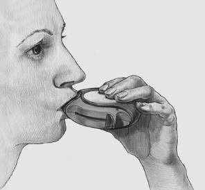 Profilo di una donna che utilizza un inalatore per farmaci tenuto con entrambe le mani e posizionato sulle labbra