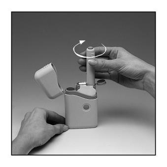 Mano che ruota un dispositivo autoiniettore penna con custodia aperta e ago esposto su superficie bianca