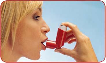 Donna che utilizza un inalatore rosso e bianco tenuto con una mano vicino alla bocca aperta