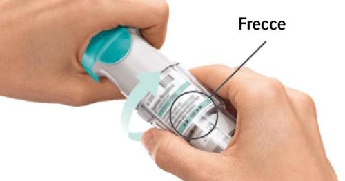 Dispositivo autoiniettante blu e bianco tenuto da una mano, con freccia che indica la rotazione e finestra trasparente con indicatore