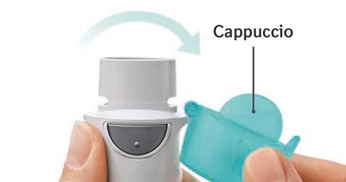 Inalatore grigio tenuto in mano con cappuccio protettivo blu che viene rimosso da un dito