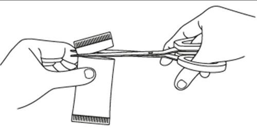 Due mani che aprono una bustina con le forbici per rivelare il contenuto interno