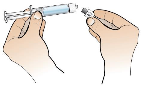 Mano che tiene una siringa e un ago separato con cappuccio protettivo, preparazione all