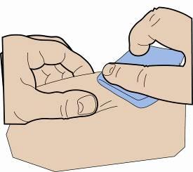 Mano che tiene un tampone blu su una zona della pelle, preparazione per un