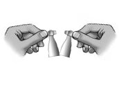 Due mani che aprono due fiale di vetro sigillate con un tappo metallico per l