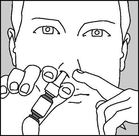 Mani che tengono un autoiniettore nasale con due dita vicino alle narici del viso di una persona