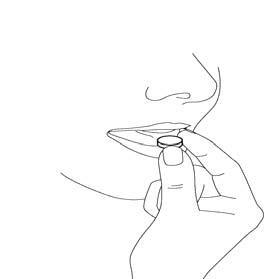 Mano che tiene una compressa rotonda e piatta tra pollice e indice pronta per l