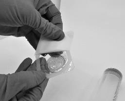 Mano con guanto che pulisce un inalatore nasale bianco con un tampone sterile bianco per disinfettare