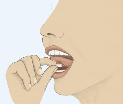 Mano che inserisce una compressa bianca in bocca con le labbra leggermente aperte