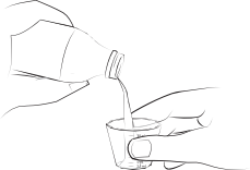 Mano che versa un liquido da una bottiglia in un bicchiere piccolo tenuto da un