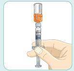 Siringa pre-riempita con liquido arancione e parte trasparente tenuta in mano con guanto bianco