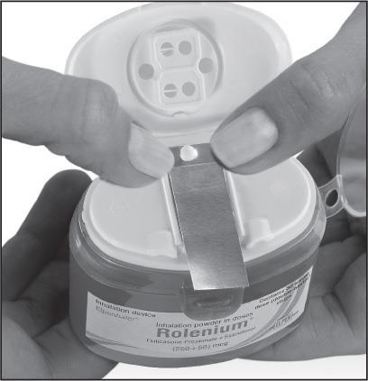 Mano che strappa una striscia di alluminio da un contenitore di polvere per inalazione Rolenium con l