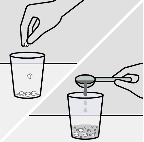 Compresse bianche cadono in un bicchiere d