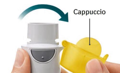 Dispositivo inalatorio grigio con cappuccio giallo parzialmente rimosso e freccia verde che indica la direzione